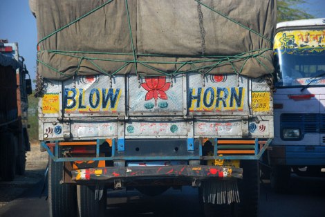 'Blow horn' squeezing through a space in traffic on a two-lane 'highway' in India