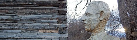 A man carved from wood stands watch on an old cabin at Gellatly Nut Farm Regional Park near Peachland in the BC Okanogan, Canada