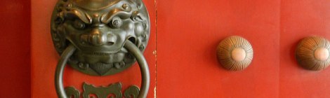 Brass lion door pull on the red door of a Chinese Temple in Singapore