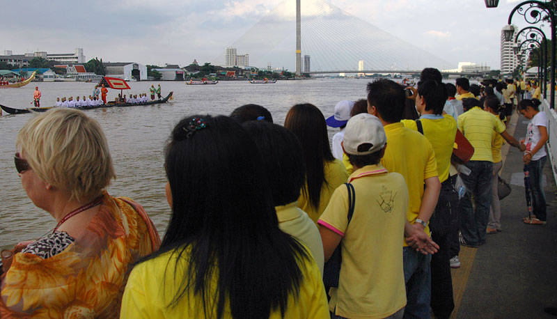 Crowds in yellow watch the Royal Barge procession in Bangkok to mark the 80th birthday of King Bhumibol